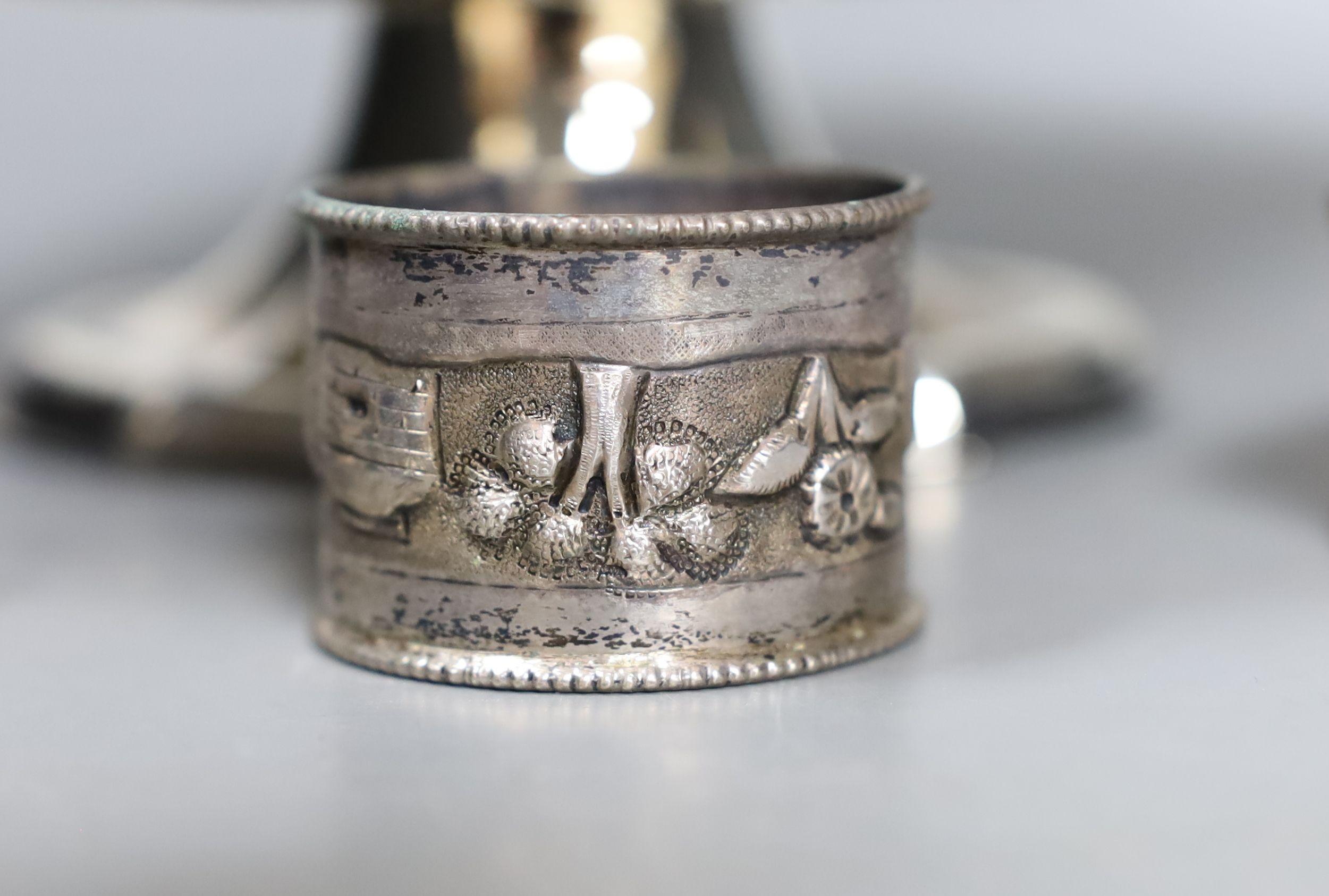 An Edwardian repousse silver pedestal bowl, Sheffield, 1901, 28.5cm and three silver napkin rings, 12.5oz.